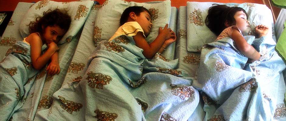 Three Kids Lying at Cots at a Daycare Center | Tri djeteta u krevetićima u vrtiću